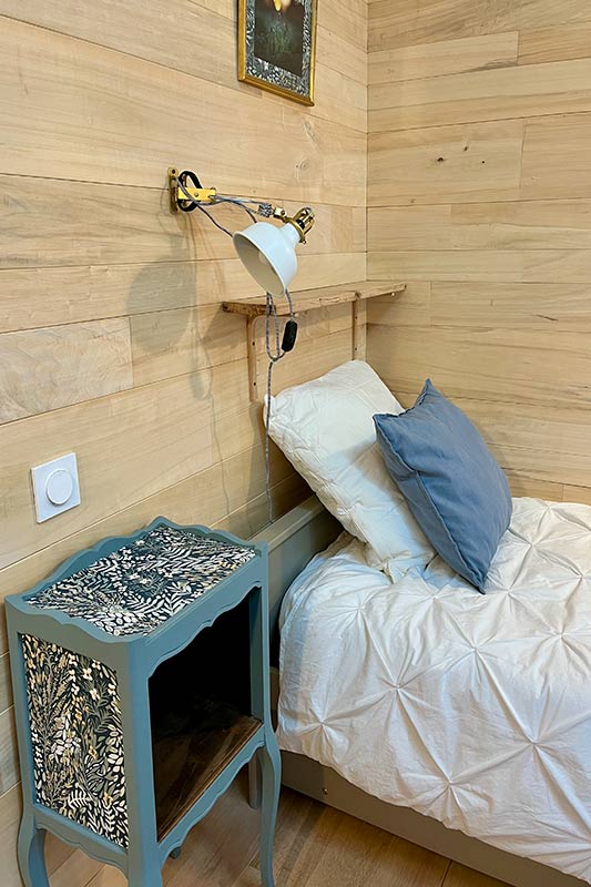 Lit 1 place avec sa table de nuit chiné et bleue Table de nuit chinée, papier peint fleuri, coussin bleu pour cette chambre