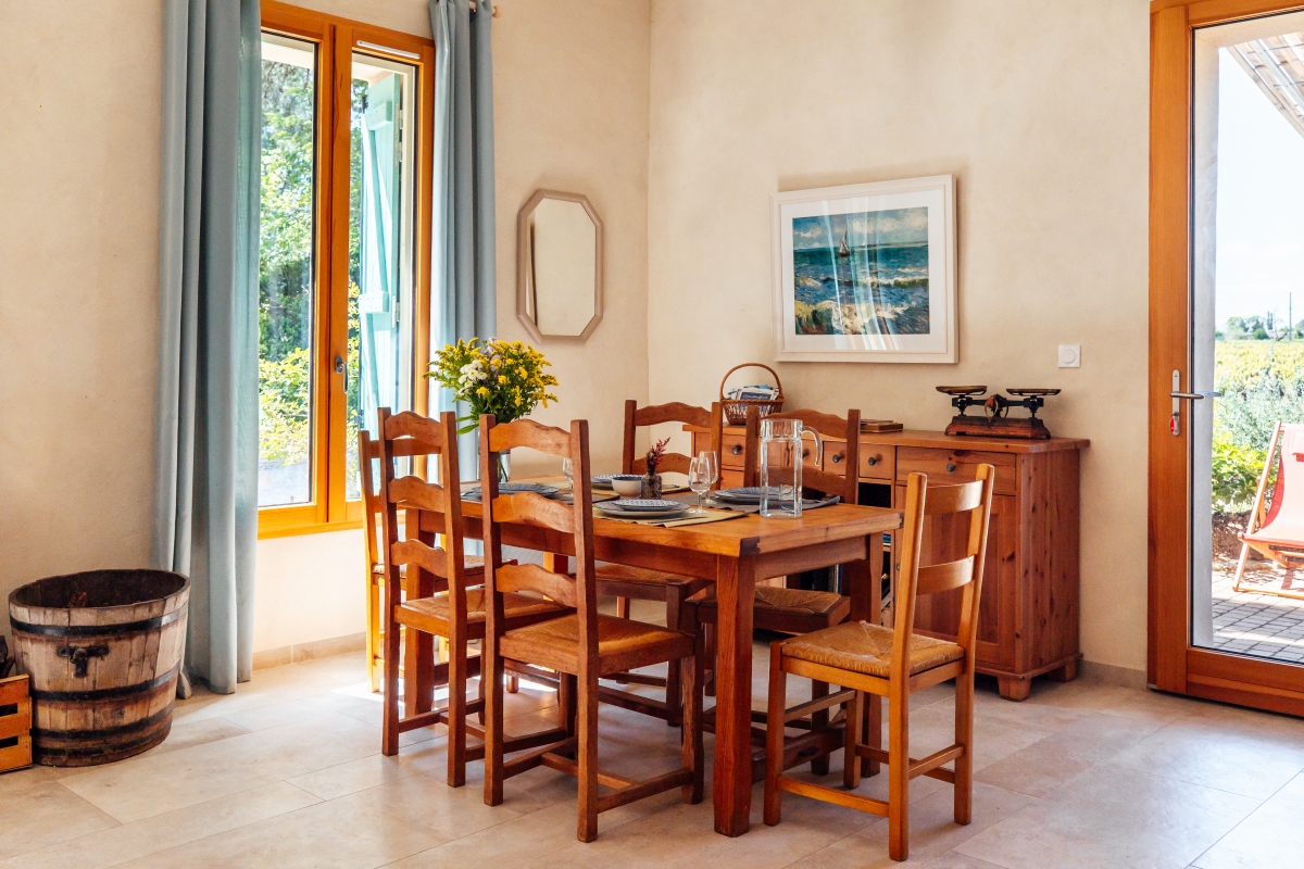Salle à manger familiale du gîte garance La salle à manger lumineuse du gîte Garance avec grande table en bois pour toute la famille