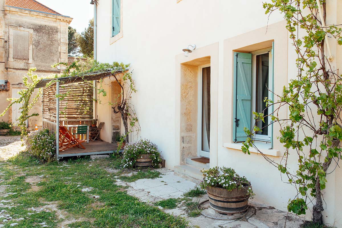 Depuis la cour du domaine viticole, l'accès à la terrasse privative du gite Lentisque, éco-gîte