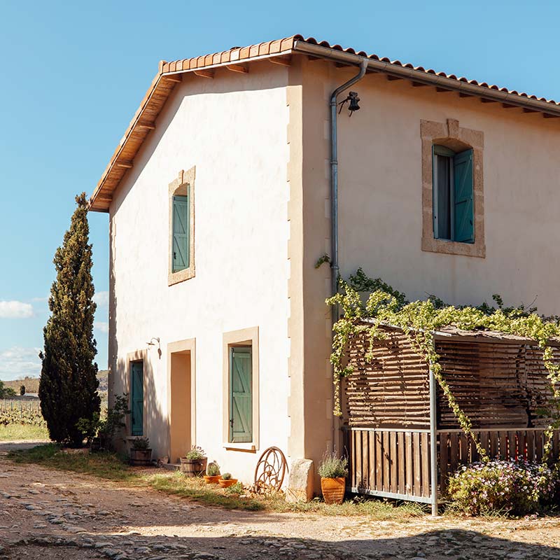 La batisse rénovée du gîte Lentisque avec sa terrasse privative dans la cour du domaine viticole