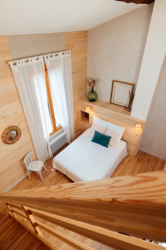 Chambre parentale lumineuse vue depuis sa mezzanine et vue sur la cour du domaine