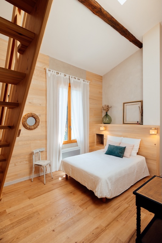 La chambre avec ses poutres apparentes rose et bleu