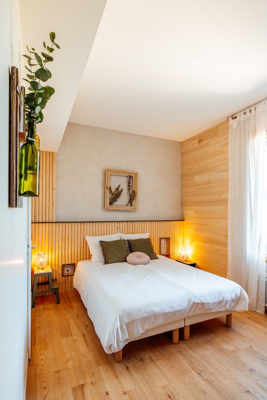 La chambre verte avec tête de lit au forme arrondi en bois et cadre chiné
