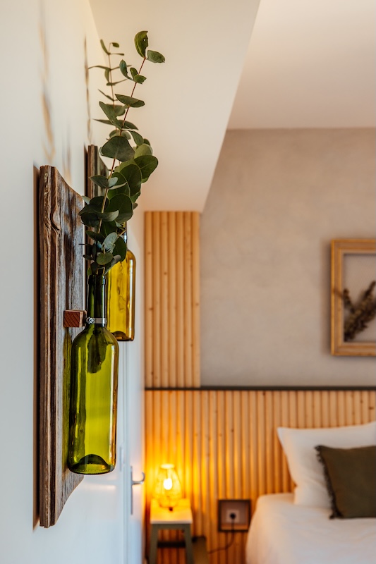 Une décoration avec des bouteilles de vins pour la chambre verte