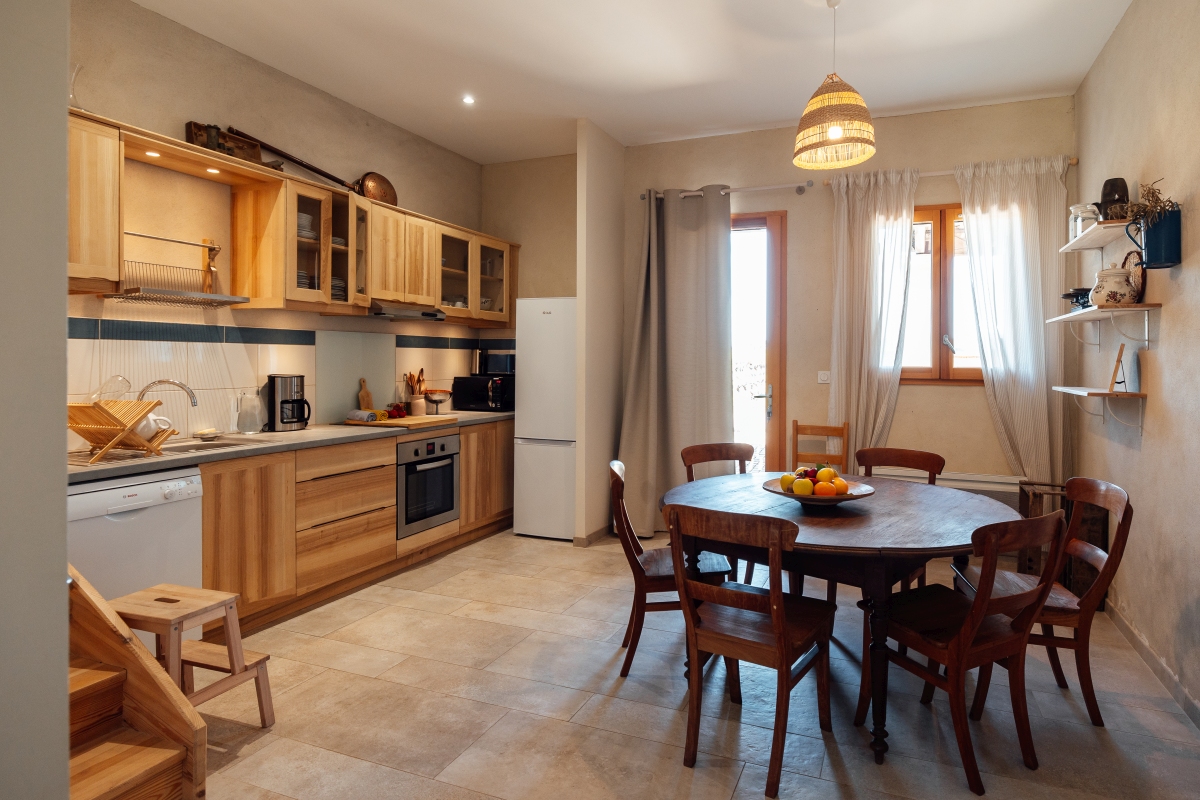 Grande cuisine et sa table ronde en bois pour 8 personnes du grand gîte