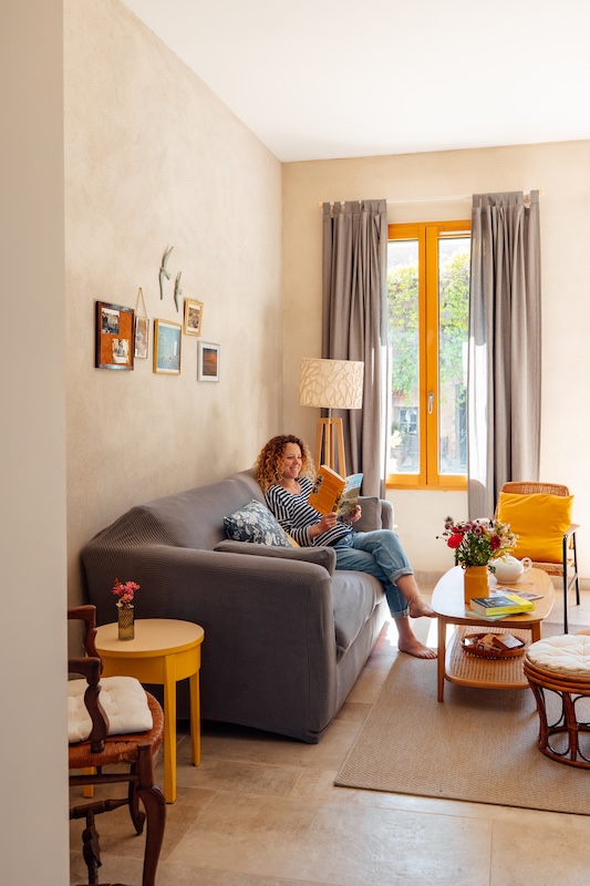 Pause lecture dans le salon cosy avec tapis, bois et lumière naturelle