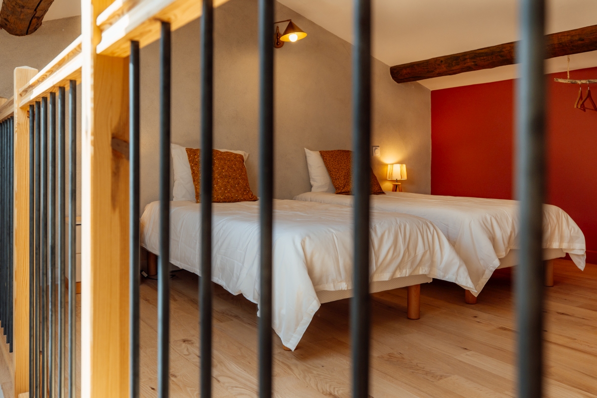 La mezzanine terracota avec poutre apparente et 2 lits séparés pour enfants ou amis