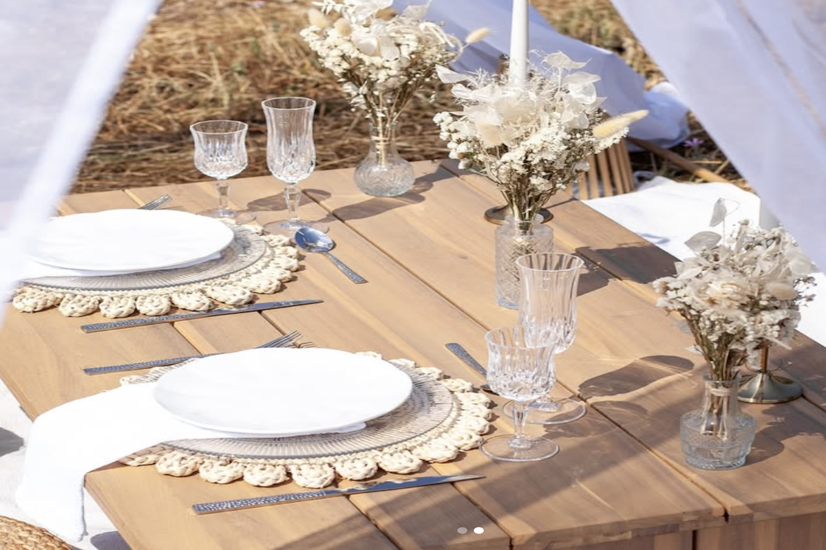 Un tipi blanc, une table joliment dressée, le soleil couchant dans les vignes