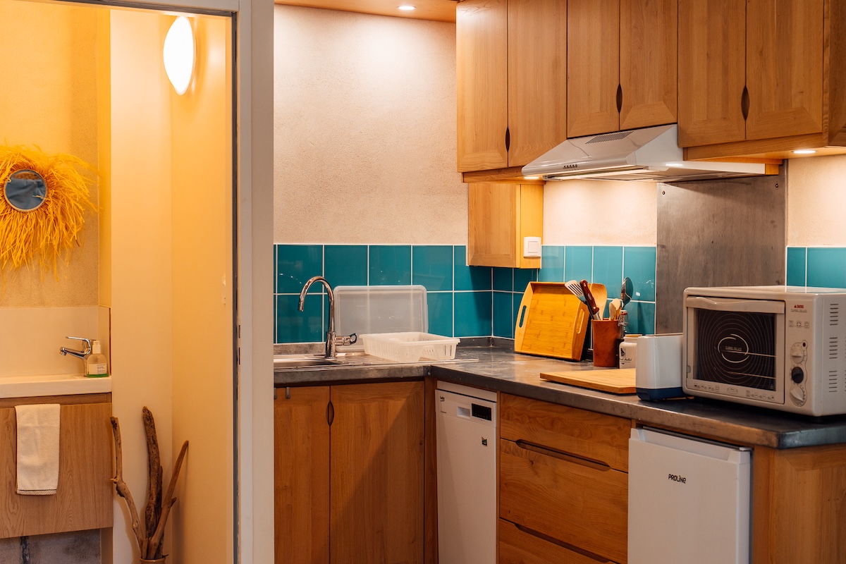 La cuisine du gîte avec crédence bleue fonctionnelle pour 2 personne et les wc au rez de chaussée