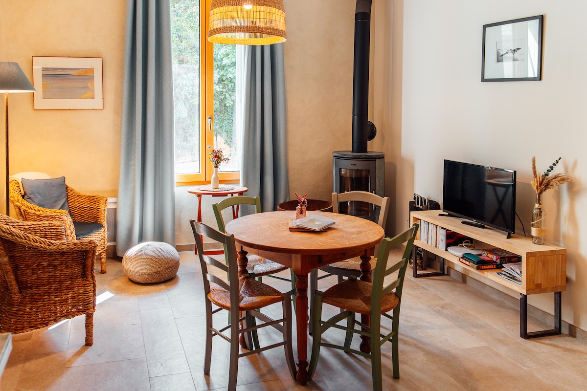 Le salon et salle à manger du gîte avec son poêle à bois pour une ambiance cocooning